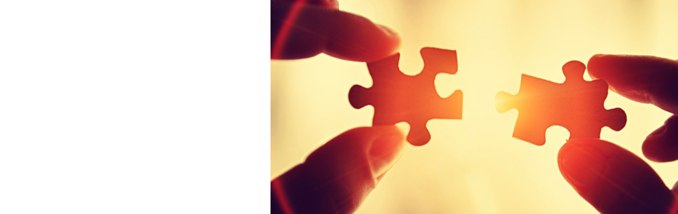 Puzzle pieces coming together with fingers visible