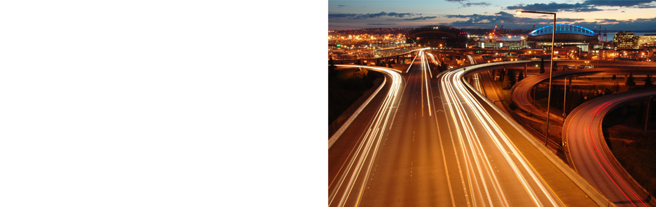 Generic city skyline with color streams of light from passing cars on onramps and offramps